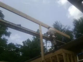 Carpenter setting a ridge beam over a new addition frame — Ice Dam Removal by Roofing Brothers in Neshanic Station