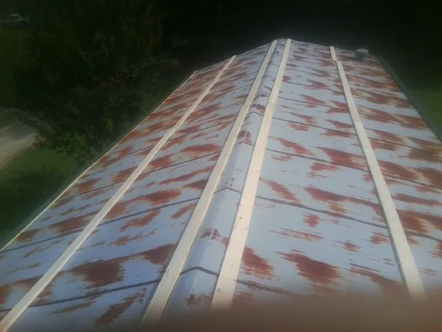 Rusted metal roof panels with new wood purlins before replacement — Storm Damage Roof Repair in Neshanic Station by Roofing Brothers