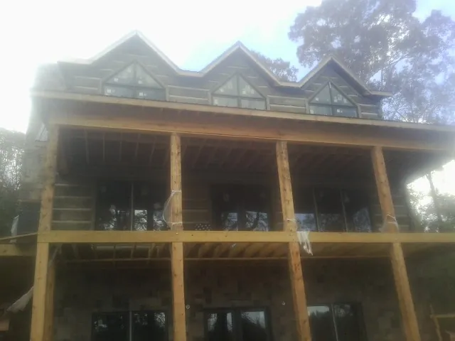 Dormers and porch framing on a large log home under construction — Roof Coating work by our crew in Neshanic Station