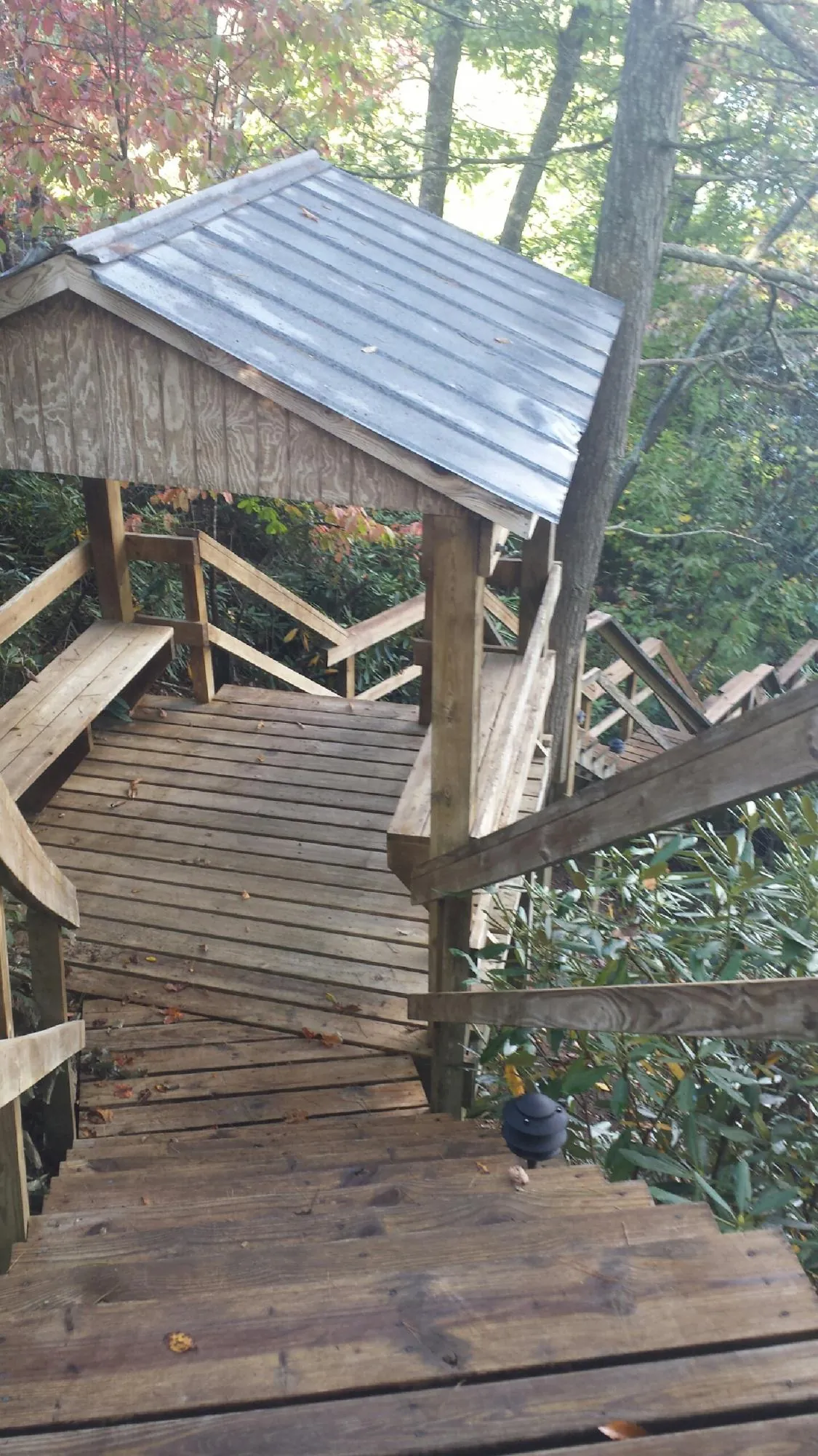 Metal roofed shelter over wooden steps on a wooded walkway — Skylight Repair & Installation work by our crew in Neshanic Station